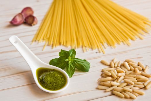 Closeup of pesto genovese sauce and linguine pasta, pine nuts and garlic on a table