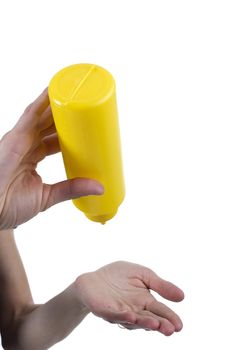 Yellow tube for sauces in female hands on a white background