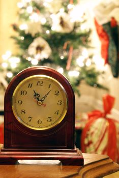Mantle clock with Christmas tree blurred in background.