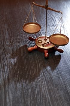 Old brass weight scales on dark wooden background with free space