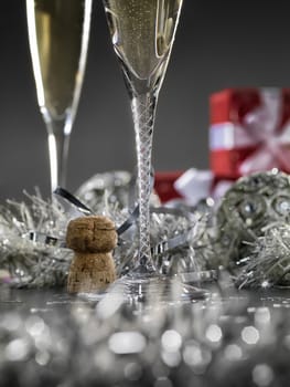 Beautiful silver christmas card with champagne and gifts in the background. Close up.