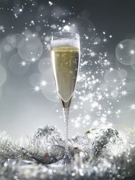 One champagne glass and silver decoration on a silver shiny glitter background