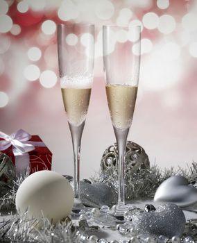 two glasses of champagne for christmas celebration with red decoration and gift