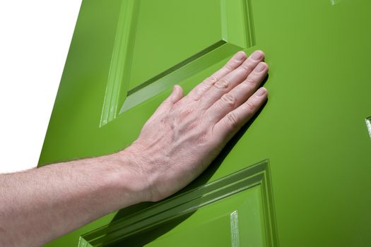 Man pushes a green door open with her hand