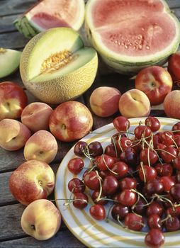 variety of fruits on a wooden table in the garden
