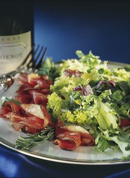  Beef Carpaccio with salad and fork on a dark background