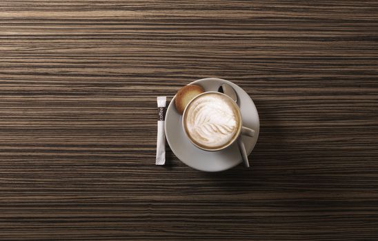 Cappuccino from above with spoon on a wooden background
