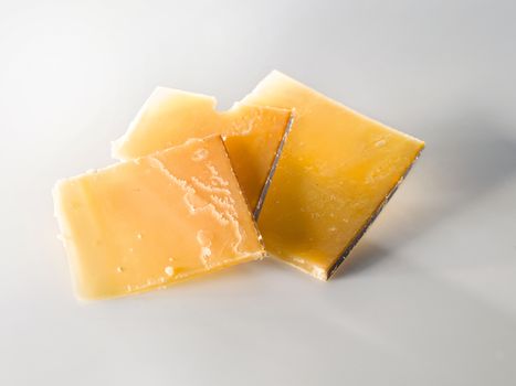 Very old cheese in slices. three square pieces