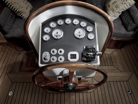 Vintage wooden boat with steering wheel and dashboard.