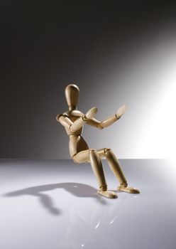 Wooden Dummy Doll sitting without a chair on gradient background