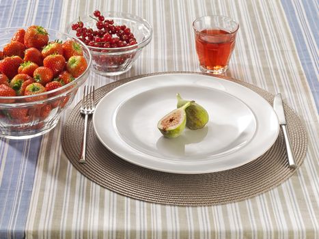Table with red fruits on a plate