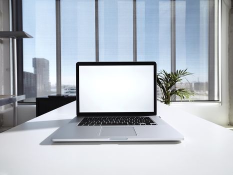 Computer in a office with window on a sunny day