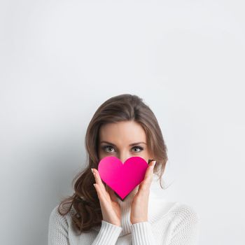 Beautiful woman holding Valentines day paper heart card