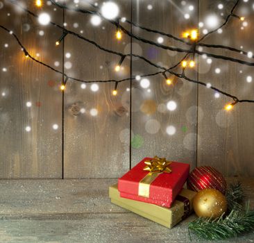 Christmas gifts and decorative lights on a wooden background with space