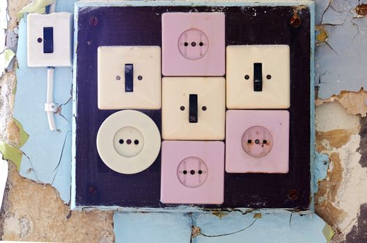 Set of old sockets and switches on rustic wall