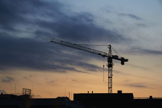 Crane silhouette over the sunset at the construction site