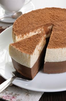 Cut a piece of chocolate with vanilla mousse cake covered  cocoa