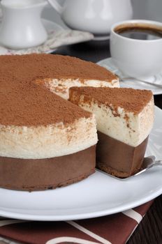 Cut a piece of chocolate with vanilla mousse cake covered  cocoa