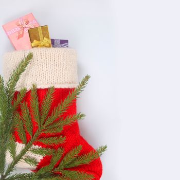 Red Christmas sock with gifts on white background