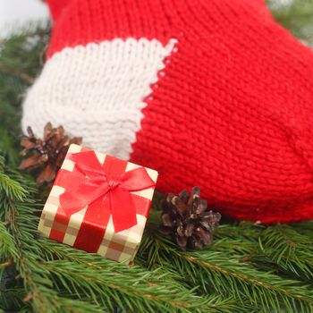 Red Christmas sock with gifts on fir tree background