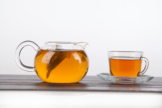 Glass teapot and cup of tea on an isolated studio background
