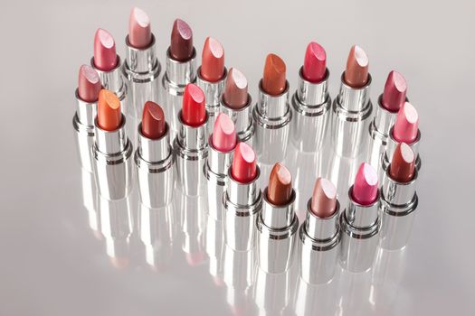 Tubes with different kinds of lipstick on studio background