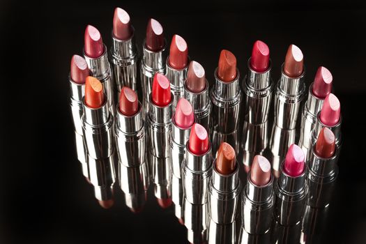 Tubes with different kinds of lipstick on studio background