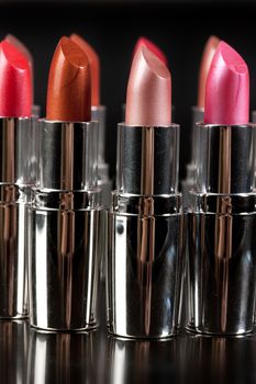 Tubes with different kinds of lipstick on studio background