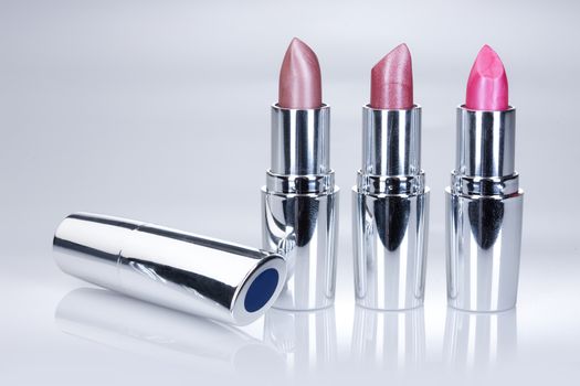 Metal tubes with lipstick on an isolted studio background