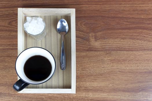 Black Coffee and rock sugar in wood tray on wood table