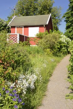 Idyllic red cottage in botanical garden.