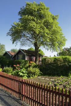 Idyllic red cottage in botanical garden.