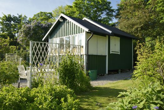 Idyllic green cottage in botanical garden.