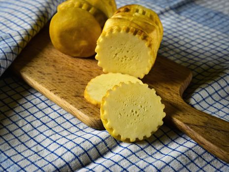 food background traditional sheep smoked cheese on a wooden plate