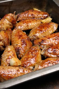 Fried sharply spicy chicken wings on a baking closeup