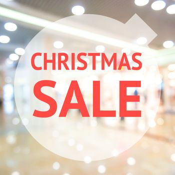 Christmas sale sign over blurred store background. Design for shop and sale banners