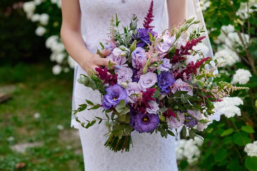 bride holding a beautiful bridal bouquet on walk