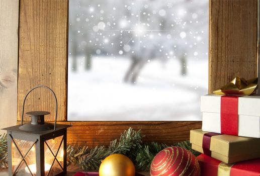 Xmas gifts decorations and a lantern next to a winter window with snow outdoors