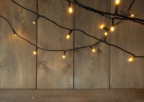 Christmas decorative lights on a wooden background with space