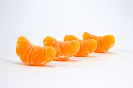 Row of four parts of tangerine posed on a white background