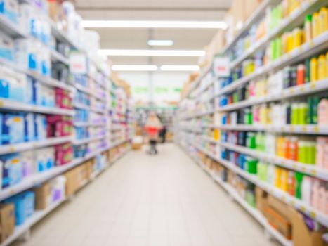 Abstract blurred supermarket aisle with colorful shelves and unrecognizable customers as background