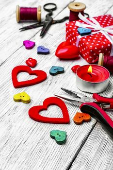 Packing holiday gifts for Valentine's day.Thread,button and symbolic heart.