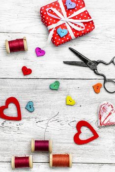 Packing holiday gifts for Valentine's day.Thread,button and symbolic heart.