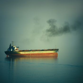 Fuming Bulk Carrier Ship in the Black Sea at the Evening