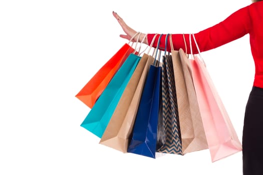 Colourful and bright shopping paper packages hanging on female red-sleeved arm