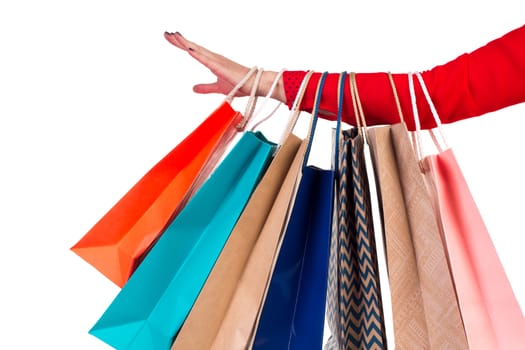 Colourful and bright shopping paper packages hanging on female red-sleeved arm