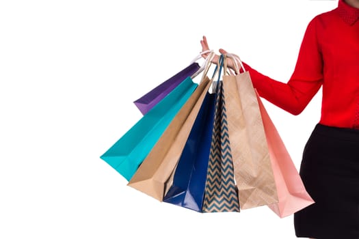 Colourful and bright shopping paper packages hanging on female right hand