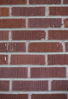 Vertical image of dark red brick wall