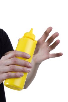 Yellow tube for sauces in female hands on a white background