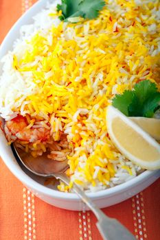 Indian Biryani with Shrimp and lime on a white plate